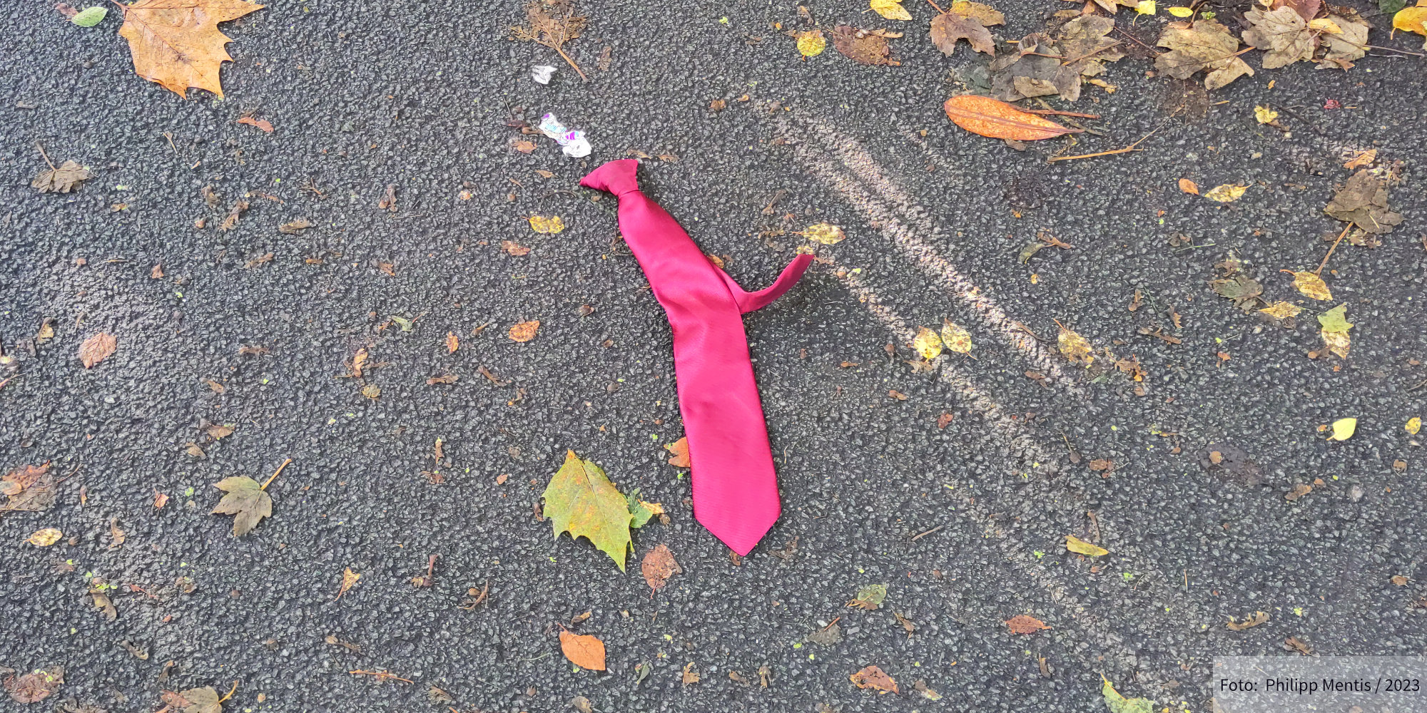 !B A tie is lying on the asphalt in Anfield Park, Liverpool.