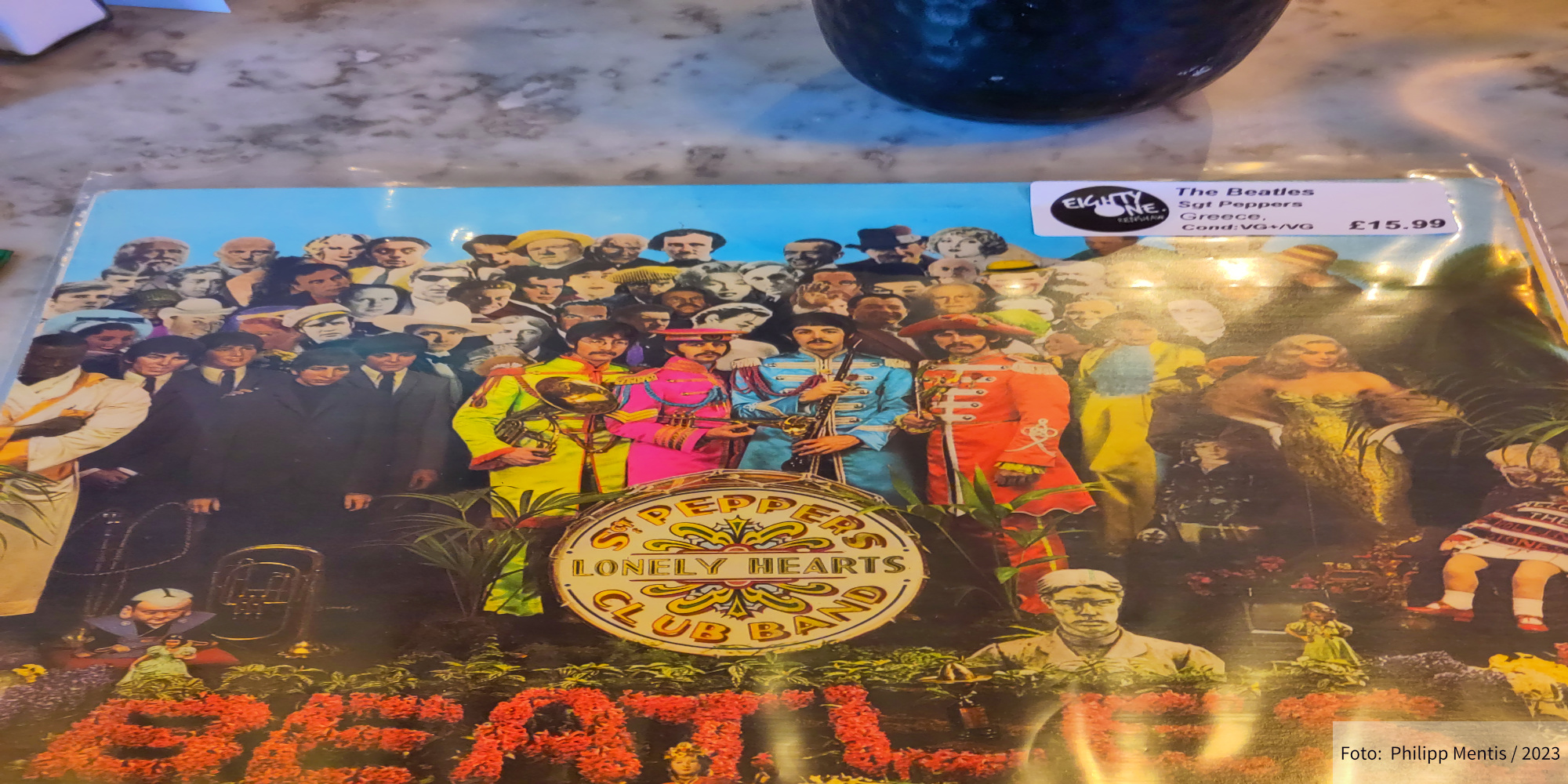 !B A second-hand vinyl LP of the Beatles album Sgt. Pepper's Lonely Hearts Club Band lies on a table.